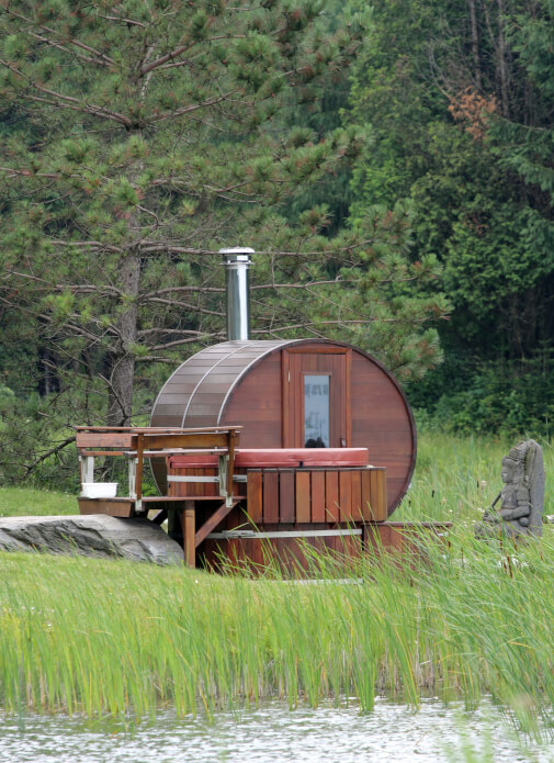 Traditional barrel sauna with deck on the edge of a lake Traditional barrel sauna with deck on the edge of a lake