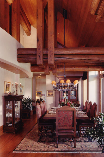 Formal dining room with seating for eight people. Dining furniture situated on large rug. China cabinet on the side of the room. Tall sloping ceiling above. Formal dining room with seating for eight people. Dining furniture situated on large rug. China cabinet on the side of the room. Tall sloping ceiling above.