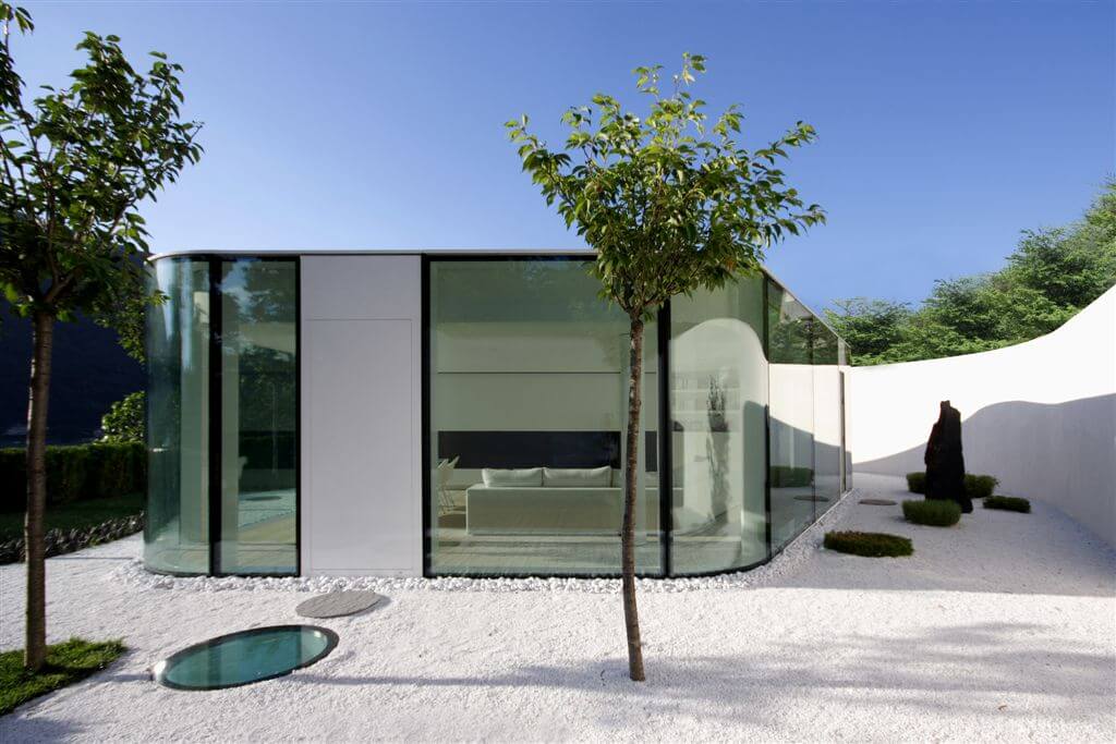 Lake Lugano House is built on a slope which required a retaining wall to create flat surface area for the structure Lake Lugano House is built on a slope which required a retaining wall to create flat surface area for the structure