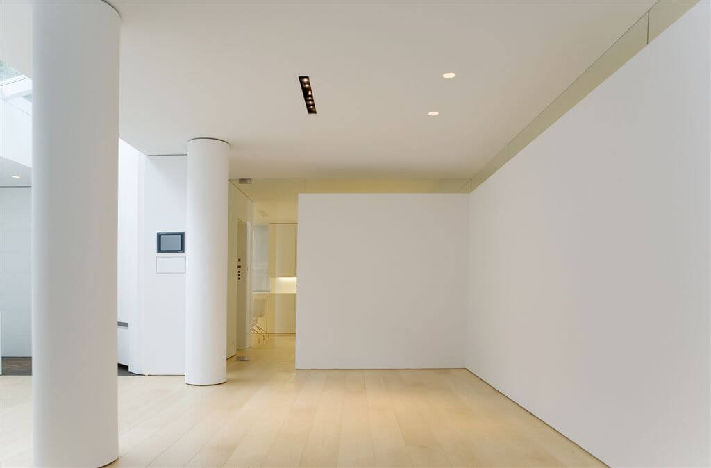 Common area replete with large white pillars, light hardwood flooring and skylights in corner. Common area replete with large white pillars, light hardwood flooring and skylights in corner.