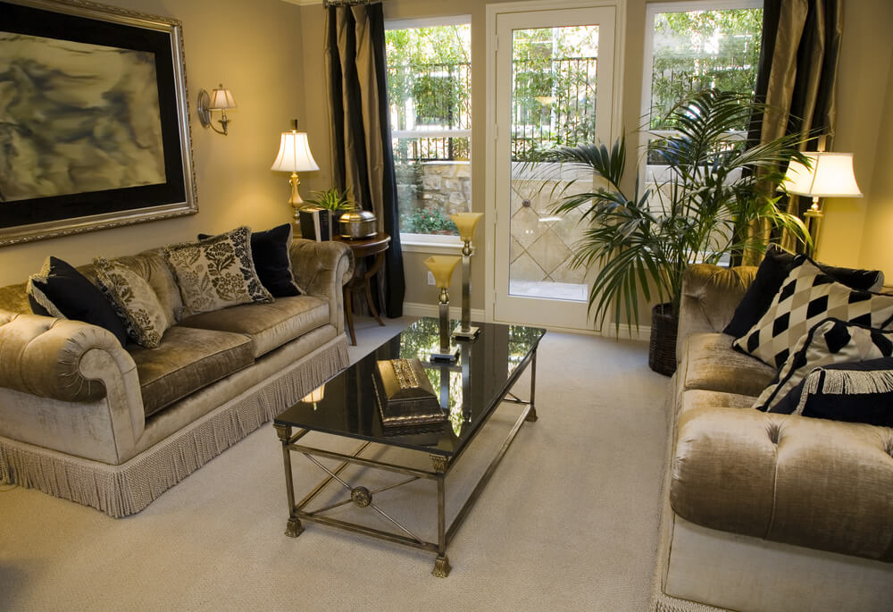 Simple living room design with extra touches that make it noteworthy such as dark green drapes, lamps on antique round wood tables in the corners and matching gold/green sofas. Simple living room design with extra touches that make it noteworthy such as dark green drapes, lamps on antique round wood tables in the corners and matching gold/green sofas.