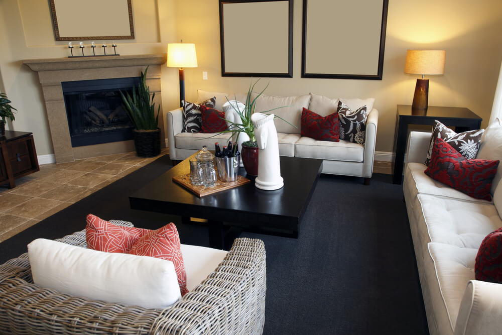 Living room with two white sofas and a wicker armchair around a dark coffee table. Living room with two white sofas and a wicker armchair around a dark coffee table.