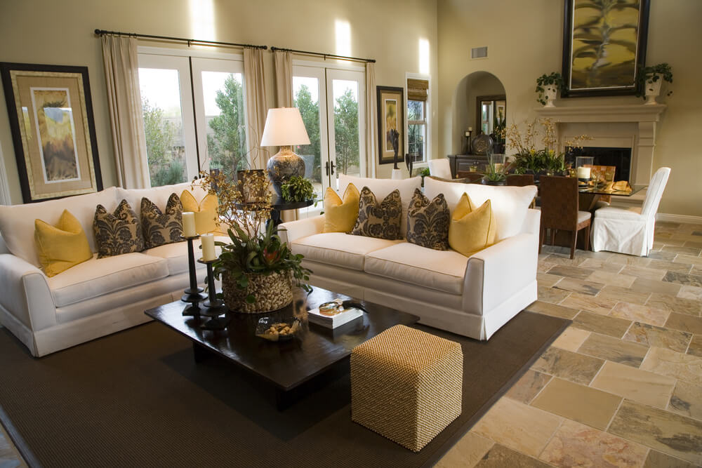 Large open concept home with dedicated living room comprised of two white sofas decorated with yellow and brown pillows. Large open concept home with dedicated living room comprised of two white sofas decorated with yellow and brown pillows.