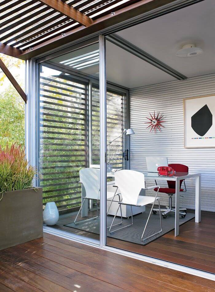 This module is configured as an office, with minimalist glass and metal desk, steel walls, and hardwood flooring extending to patio. This module is configured as an office, with minimalist glass and metal desk, steel walls, and hardwood flooring extending to patio.