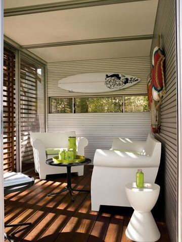 KitHaus interior flush with bright white furniture, black table and details like surfboard and life rings mounted on walls. KitHaus interior flush with bright white furniture, black table and details like surfboard and life rings mounted on walls.