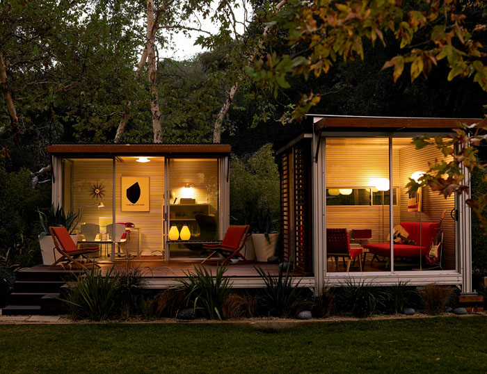 This KitHaus features two modules set on a shared patio space. Red furniture and white interiors cast bright contrast. This KitHaus features two modules set on a shared patio space. Red furniture and white interiors cast bright contrast.