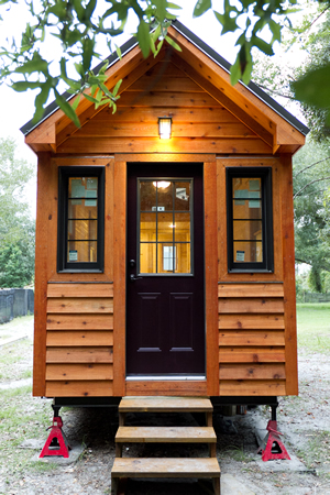 This is an identical tiny home, situated in a more traditional yard setting. Black door and window surrounds add contrast to the exterior. This is an identical tiny home, situated in a more traditional yard setting. Black door and window surrounds add contrast to the exterior.