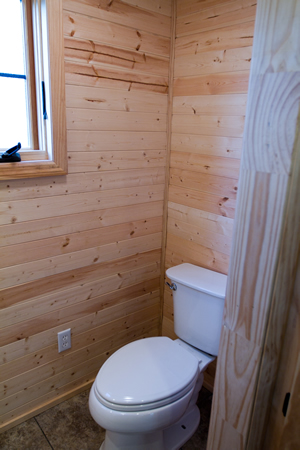 Compact bathroom at end of home features standard amenities. Compact bathroom at end of home features standard amenities.