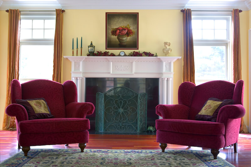 In front of a fireplace, these matching red armchairs with a subtle swirl pattern provide a satisfying pop of color in contrast to the white mantle. They're wide enough to curl up comfortably with a book next to the fire. In front of a fireplace, these matching red armchairs with a subtle swirl pattern provide a satisfying pop of color in contrast to the white mantle. They're wide enough to curl up comfortably with a book next to the fire.