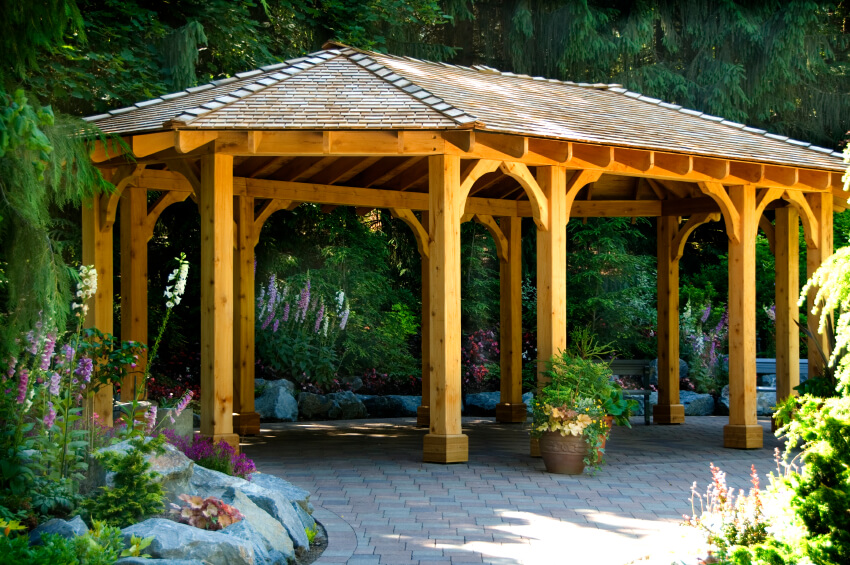 An open design ensures that there's plenty of space for a large gathering to move around without having a traffic jam at the entrance. This gazebo is tucked near a forest and surrounded by flowers. An open design ensures that there's plenty of space for a large gathering to move around without having a traffic jam at the entrance. This gazebo is tucked near a forest and surrounded by flowers.