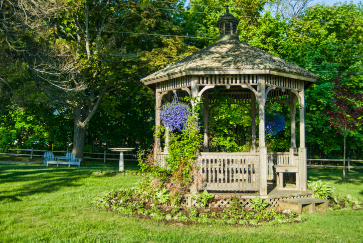 Even in the center of the yard, adding vines, hanging baskets, and planting beds around the gazebo helps create a sense of being in a secret garden. Even in the center of the yard, adding vines, hanging baskets, and planting beds around the gazebo helps create a sense of being in a secret garden.