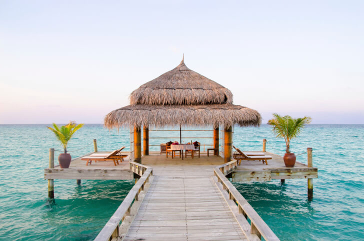 This screened gazebo is located at the center of a dock above the turquoise waters of this tropical sea. This screened gazebo is located at the center of a dock above the turquoise waters of this tropical sea.