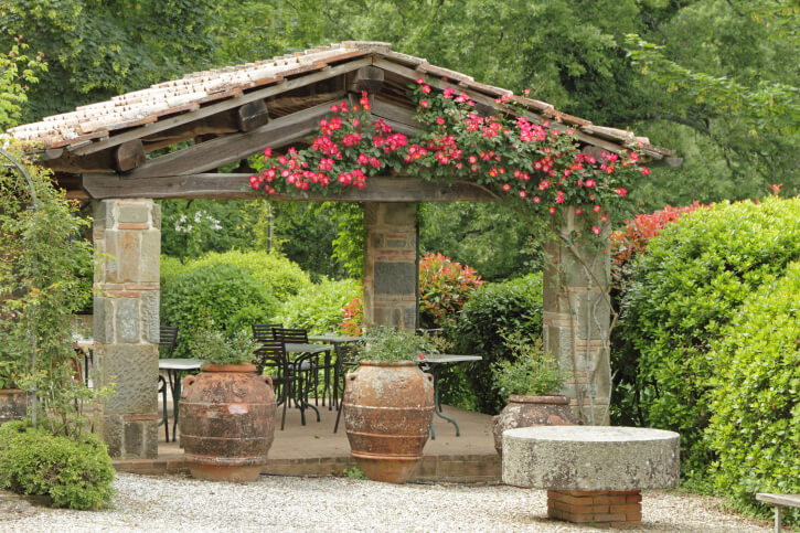 This is a great example of a custom gazebo made out of stone, which isn't exactly a common material. Trailing flowers up the supports gives this gazebo a huge pop of color. This is a great example of a custom gazebo made out of stone, which isn't exactly a common material. Trailing flowers up the supports gives this gazebo a huge pop of color.