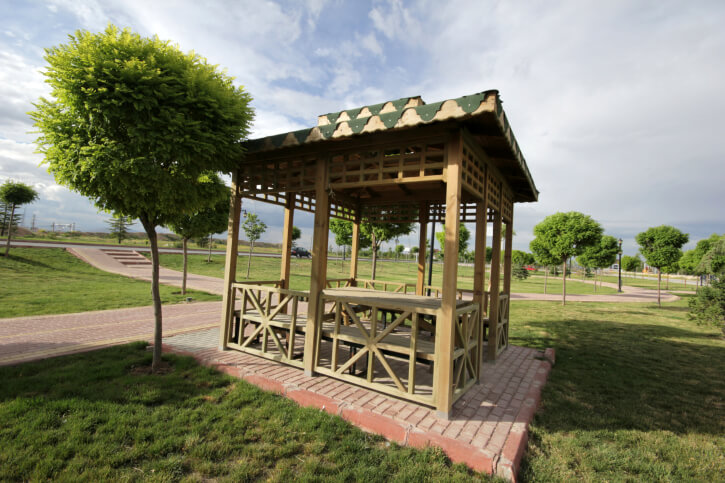 An eclectic square gazebo with clever details on the roof and a sunburst design on the sides. The structure is a nice spot to rest off the brick pathway. An eclectic square gazebo with clever details on the roof and a sunburst design on the sides. The structure is a nice spot to rest off the brick pathway.