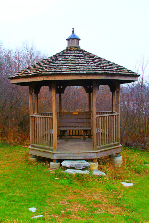 A rustic gazebo in the fall. The structure stands on concrete supports, since the landscape isn't totally flat. A rustic gazebo in the fall. The structure stands on concrete supports, since the landscape isn't totally flat.