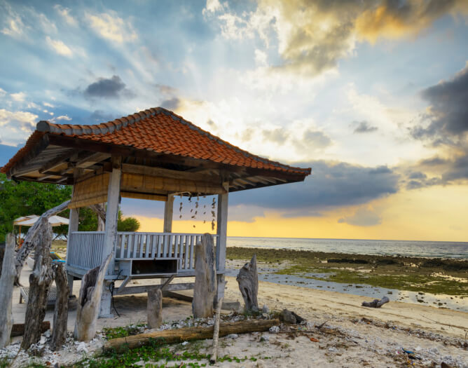 An Asian-inspired gazebo on the beach surrounded by a makeshift driftwood fence. This is a great spot to sit and watch the sunset before leaving the beach for the night. An Asian-inspired gazebo on the beach surrounded by a makeshift driftwood fence. This is a great spot to sit and watch the sunset before leaving the beach for the night.