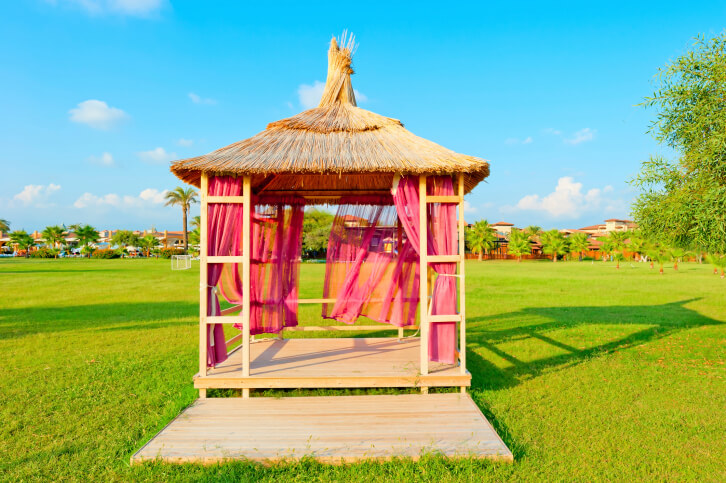 This soft-top gazebo features a rustic roof and magenta curtains. This soft-top gazebo features a rustic roof and magenta curtains.