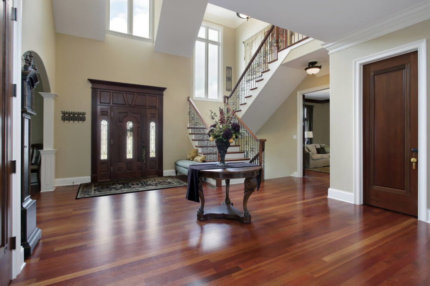 Upscale home with large entry foyer. Half-landing stairs are to the left when facing indoors. Stairs are white and natural wood. Round table is placed in the center of the space. Foyer opens up to other rooms in the home. Upscale home with large entry foyer. Half-landing stairs are to the left when facing indoors. Stairs are white and natural wood. Round table is placed in the center of the space. Foyer opens up to other rooms in the home.