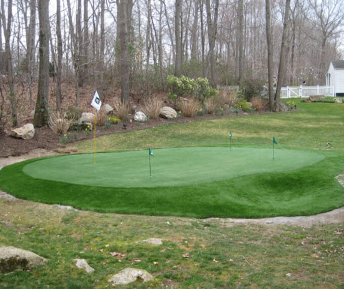 Here's a custom green neatly integrated into the surrounding lawn. Situated at the end of the yard, it features a raised surface and sloped edges for challenge. Here's a custom green neatly integrated into the surrounding lawn. Situated at the end of the yard, it features a raised surface and sloped edges for challenge.