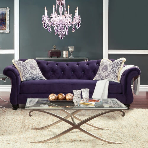 This bold royal purple sofa has a sleek, elegant silhouette that features a solid wood frame with scroll armrests, a sweetheart backrest and glossy black turned-bun feet. The backrest is adorned with crystalline acrylic button tufts that add a bit of glitz and glitter to this elegant piece. This bold royal purple sofa has a sleek, elegant silhouette that features a solid wood frame with scroll armrests, a sweetheart backrest and glossy black turned-bun feet. The backrest is adorned with crystalline acrylic button tufts that add a bit of glitz and glitter to this elegant piece.
