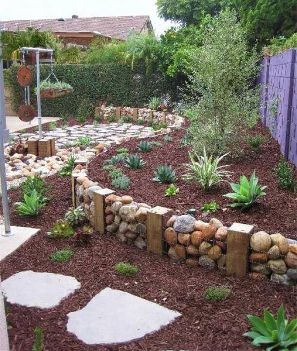 A simple terrace created with wooden blocks, chicken wire, and large stones for a rustic look. The landscaping is simple and low maintenance. A simple terrace created with wooden blocks, chicken wire, and large stones for a rustic look. The landscaping is simple and low maintenance.