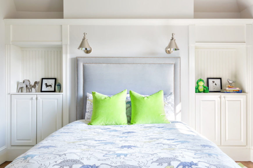 A final look at the adorable dinosaur bedding brightened up by lime green throw pillows. The built-in shelves on either side of the upholstered head board eliminate the need for nightstands. 