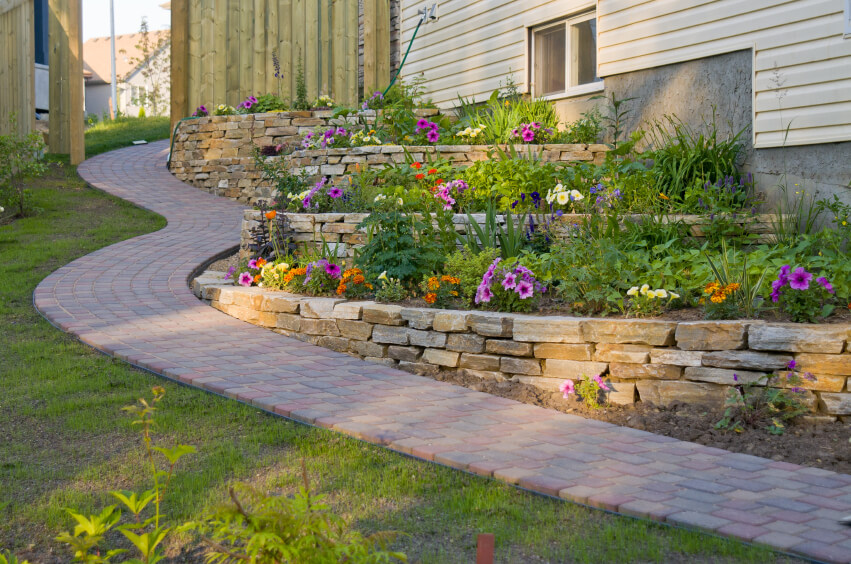 A residential terrace garden along a winding stone path along the side of the home. A residential terrace garden along a winding stone path along the side of the home.