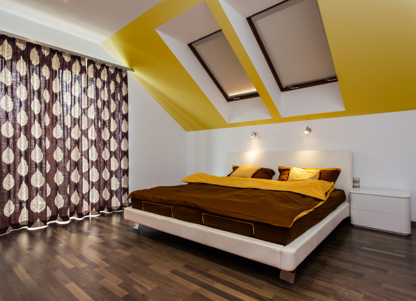 Two-toned bed linens are complemented by an accent ceiling and foliage drapes. Two-toned bed linens are complemented by an accent ceiling and foliage drapes.