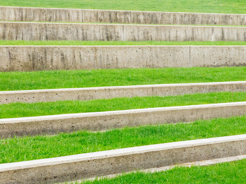 A series of small concrete terraces create steps along this hillside. Soft, plush grasses make this spot perfect for sitting. A series of small concrete terraces create steps along this hillside. Soft, plush grasses make this spot perfect for sitting.