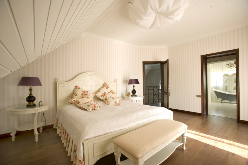 A delicate country bedroom with an adjoining spacious bathroom with a clawfoot tub. A corner door leads out to the iron-railing staircase to the lower levels of the home. A delicate country bedroom with an adjoining spacious bathroom with a clawfoot tub. A corner door leads out to the iron-railing staircase to the lower levels of the home.