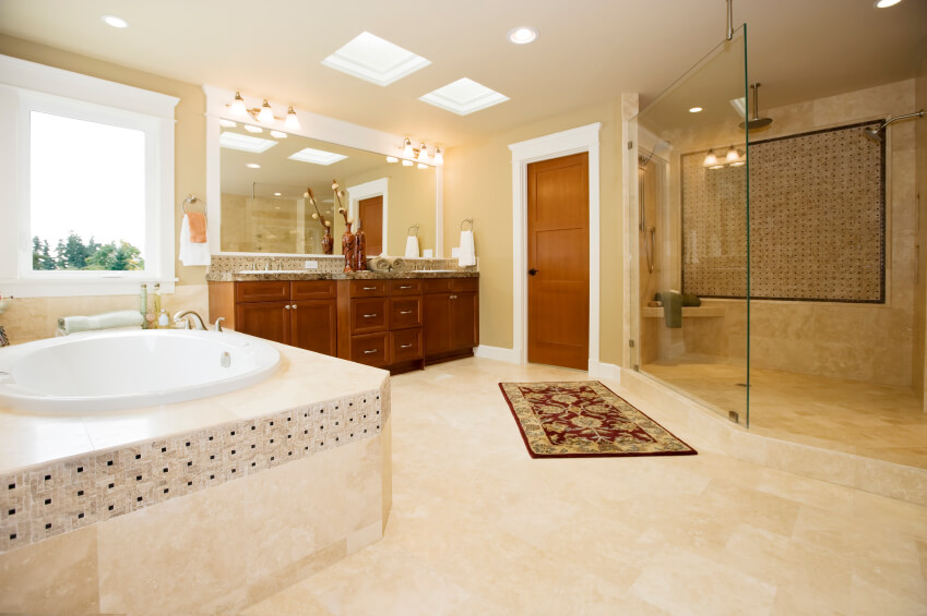 Another view of the previous bathroom shows a small oblong bathtub luxuriously encased in cream stonework with black accents. A window allows additional light to flood this already cheerful space. Another view of the previous bathroom shows a small oblong bathtub luxuriously encased in cream stonework with black accents. A window allows additional light to flood this already cheerful space.