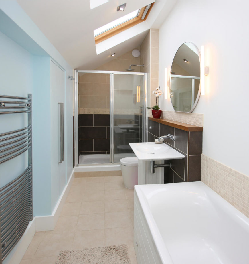 The above skylight hovers high above this simple bathroom, allowing sunlight to drench the space. The above skylight hovers high above this simple bathroom, allowing sunlight to drench the space.