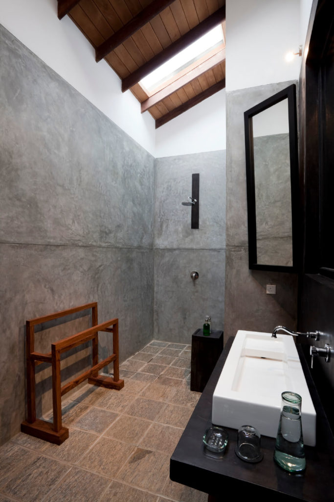 Soaring ceilings make this small bathroom feel open, while the white modern basin on the ebony vanity offers a striking contrast. During the day, the skylights allow light to filter through, brightening this otherwise dark space. Soaring ceilings make this small bathroom feel open, while the white modern basin on the ebony vanity offers a striking contrast. During the day, the skylights allow light to filter through, brightening this otherwise dark space.