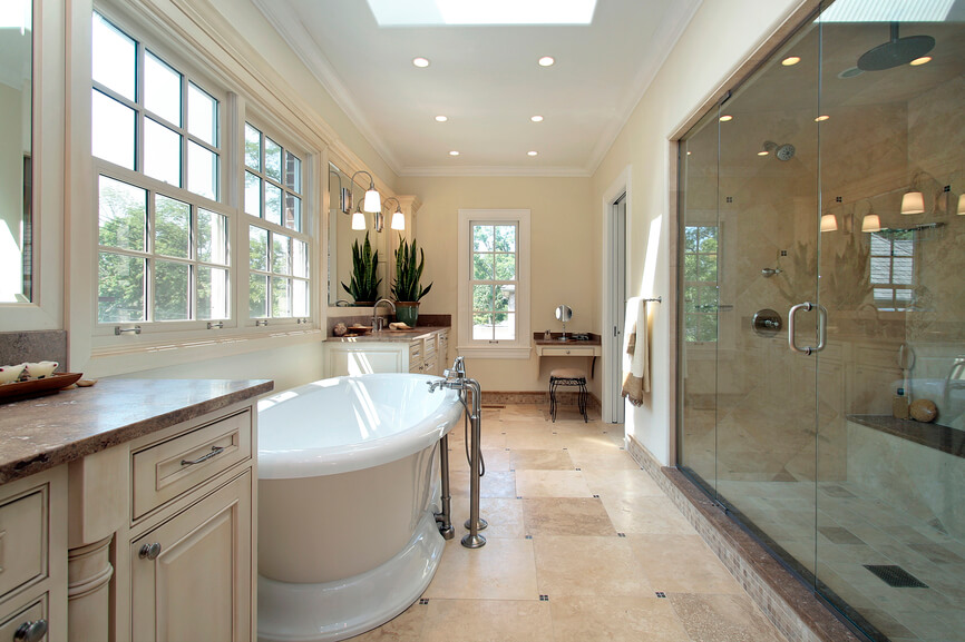 This impressive bathroom offers plenty of space. A deep porcelain bathtub boasts stainless steel spigots and plumbing, while a sizable glass enclosed shower is nearby. Recessed lighting is inset onto the crown moulded white ceiling, and a skylight complements the numerous windows already allowing for light to trickle through. Stone floor tile-work complements the soft neutrals of the walls and double vanities perfectly. This impressive bathroom offers plenty of space. A deep porcelain bathtub boasts stainless steel spigots and plumbing, while a sizable glass enclosed shower is nearby. Recessed lighting is inset onto the crown moulded white ceiling, and a skylight complements the numerous windows already allowing for light to trickle through. Stone floor tile-work complements the soft neutrals of the walls and double vanities perfectly.