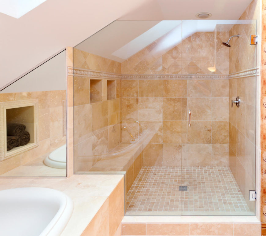 A peek of the corner of a skylight can be seen in this heavily tiled bathroom space. A peek of the corner of a skylight can be seen in this heavily tiled bathroom space.