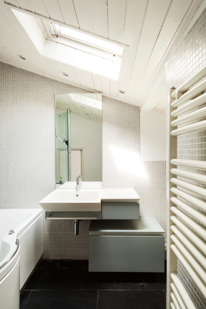 A close up of the sink area reveals a matte gray storage cabinet and additional detail of the skylight. A close up of the sink area reveals a matte gray storage cabinet and additional detail of the skylight.