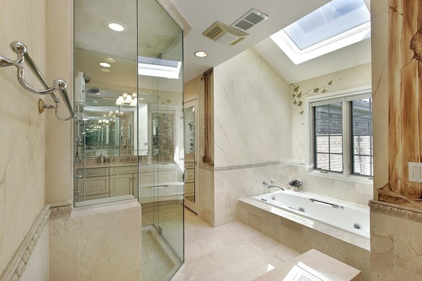 The above bathroom is elegantly designed in a cream and ivory palette. The light, glossy, stone tiled floor pairs nicely with the deeper hues of the surrounding tiled walls and bathtub encasement. A delicate spray of ivory is hand painted on the wall, as are textured faux pillars which add a classical sense of style to this space. A window above the bathtub allows a relaxing view of the outdoors, while a skylight allows rays of light to playfully bounce around the room. The above bathroom is elegantly designed in a cream and ivory palette. The light, glossy, stone tiled floor pairs nicely with the deeper hues of the surrounding tiled walls and bathtub encasement. A delicate spray of ivory is hand painted on the wall, as are textured faux pillars which add a classical sense of style to this space. A window above the bathtub allows a relaxing view of the outdoors, while a skylight allows rays of light to playfully bounce around the room.