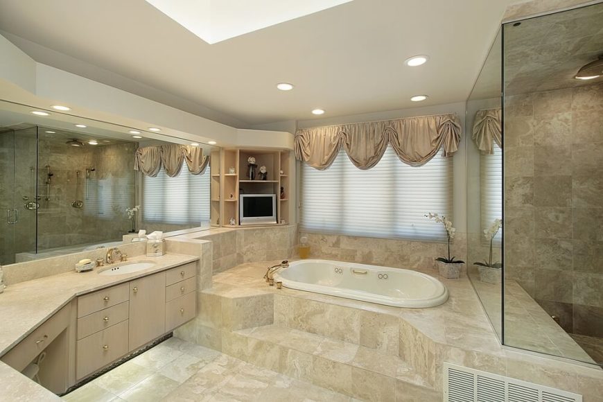 This upscale bathroom features extensive tile-work and subtly luxurious details. The recessed lighting, shaded window, and skylight work together in harmony to give this space a soft glow of natural light. Plenty of storage space is noted, and an enclosed shower area is just out of view. This upscale bathroom features extensive tile-work and subtly luxurious details. The recessed lighting, shaded window, and skylight work together in harmony to give this space a soft glow of natural light. Plenty of storage space is noted, and an enclosed shower area is just out of view.