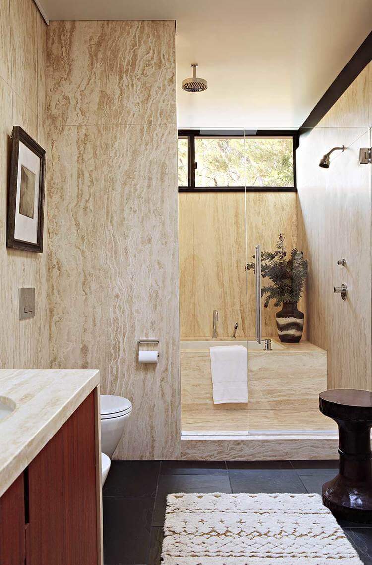 This mid-century primary bathroom features black tiles flooring along with a tall ceiling. It also features a very attractive shower and bathtub area.