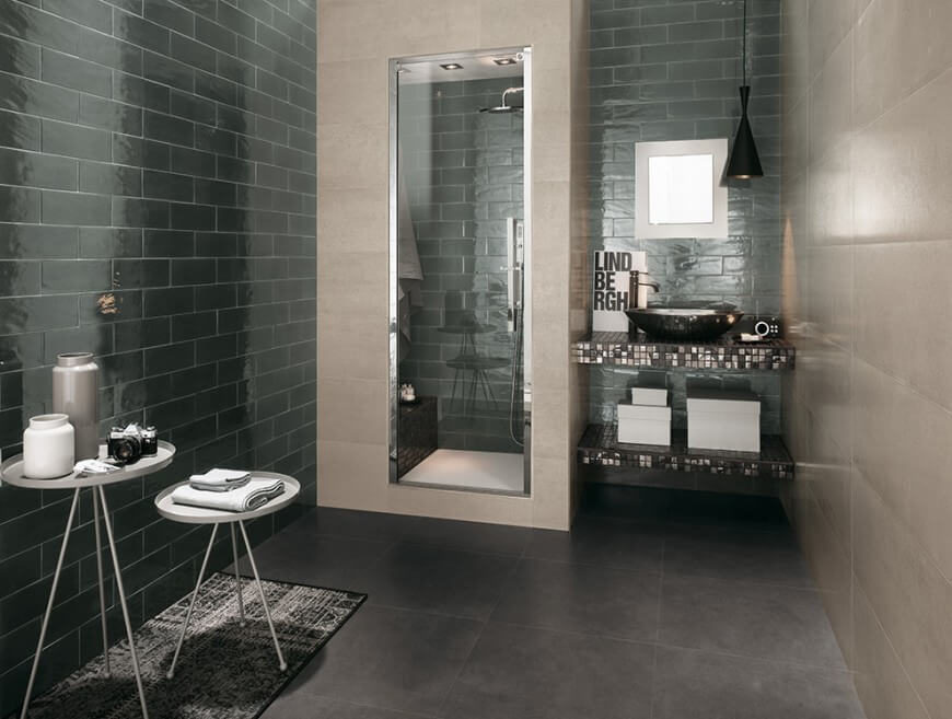 This lovely space has a shower encased by tile and a glass door. The vanity is delicately tiled with a small square window letting in just enough light for a soft white glow. This lovely space has a shower encased by tile and a glass door. The vanity is delicately tiled with a small square window letting in just enough light for a soft white glow.