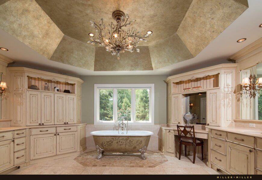 This classy bathroom features intricate designs on the bathtub and a large octogonal textured ceiling. A breath-taking chandelier with dainty crystal leaves lights this stunning space. This classy bathroom features intricate designs on the bathtub and a large octogonal textured ceiling. A breath-taking chandelier with dainty crystal leaves lights this stunning space.