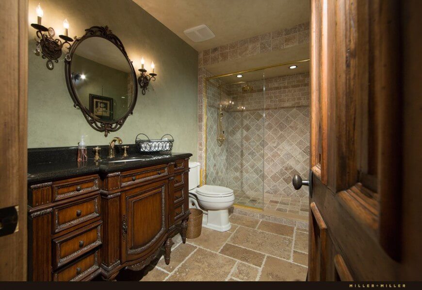 This bathroom uses a lot of dark natural wood in its dashing vanity. A stately finish of tile lines the shower for a rustic look. This bathroom uses a lot of dark natural wood in its dashing vanity. A stately finish of tile lines the shower for a rustic look.