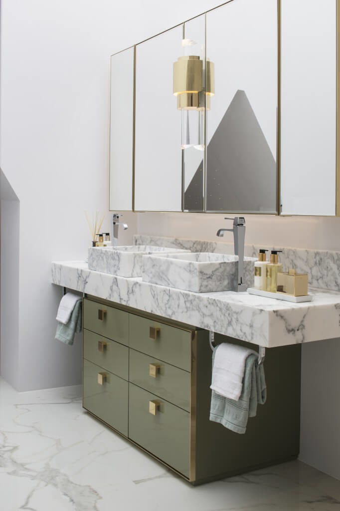 Another view of the bathroom focuses on the marble countertop of the vanity. The vessel sinks are also made of marble and the faucets come from either side of the sinks. Another view of the bathroom focuses on the marble countertop of the vanity. The vessel sinks are also made of marble and the faucets come from either side of the sinks.