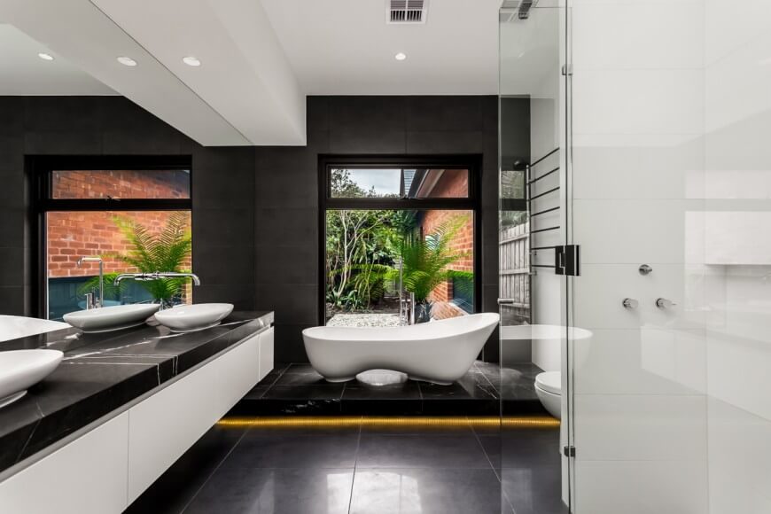 A floating vanity with glossy white vessel sinks are used in this dazzling bathroom. A unique bathtub shape has a bend and bump to give maximum relaxation when soaking. A floating vanity with glossy white vessel sinks are used in this dazzling bathroom. A unique bathtub shape has a bend and bump to give maximum relaxation when soaking.