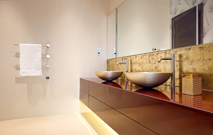 This unique bathroom features a light golden color scheme throughout the room. A soft amber glow comes from lighting under the floating vanity. This unique bathroom features a light golden color scheme throughout the room. A soft amber glow comes from lighting under the floating vanity.
