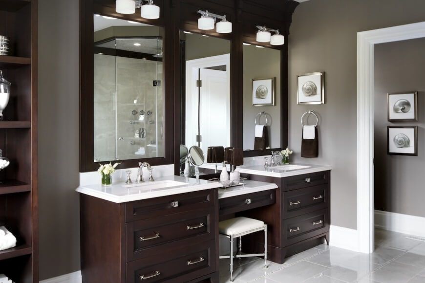This vanity is has lots of dark natural wood and storage space. A space between the two sinks gives the residents a place designated for beauty and pampering. This vanity is has lots of dark natural wood and storage space. A space between the two sinks gives the residents a place designated for beauty and pampering.