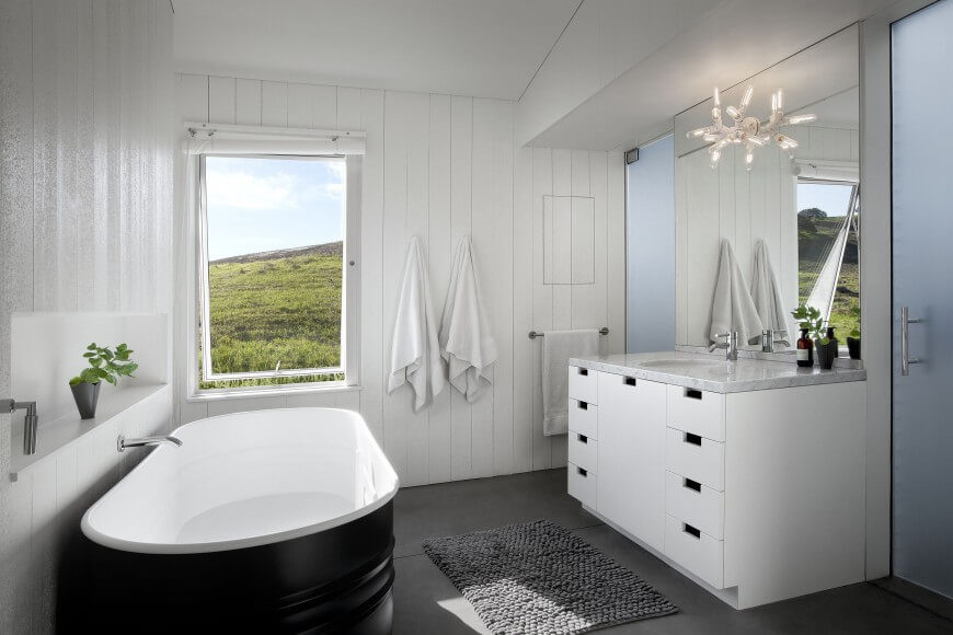 This cottage bathroom uses a lot of white colors for a bold contrast with the floor. A shelving unit is carved out of the wall for optimal storage. This cottage bathroom uses a lot of white colors for a bold contrast with the floor. A shelving unit is carved out of the wall for optimal storage.