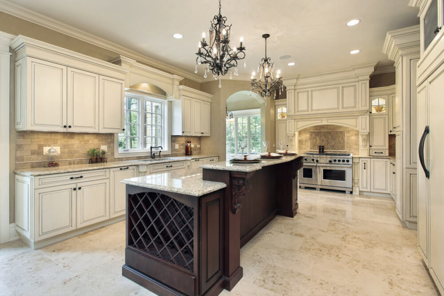 Now we come to another luxuriously appointed kitchen, bright and bold with white cabinetry and light marble flooring. The wide expanse is punctuated by the rich, dark wood two-tiered island, housing a large wine rack and plenty of in-kitchen dining space on the granite countertop. Now we come to another luxuriously appointed kitchen, bright and bold with white cabinetry and light marble flooring. The wide expanse is punctuated by the rich, dark wood two-tiered island, housing a large wine rack and plenty of in-kitchen dining space on the granite countertop.