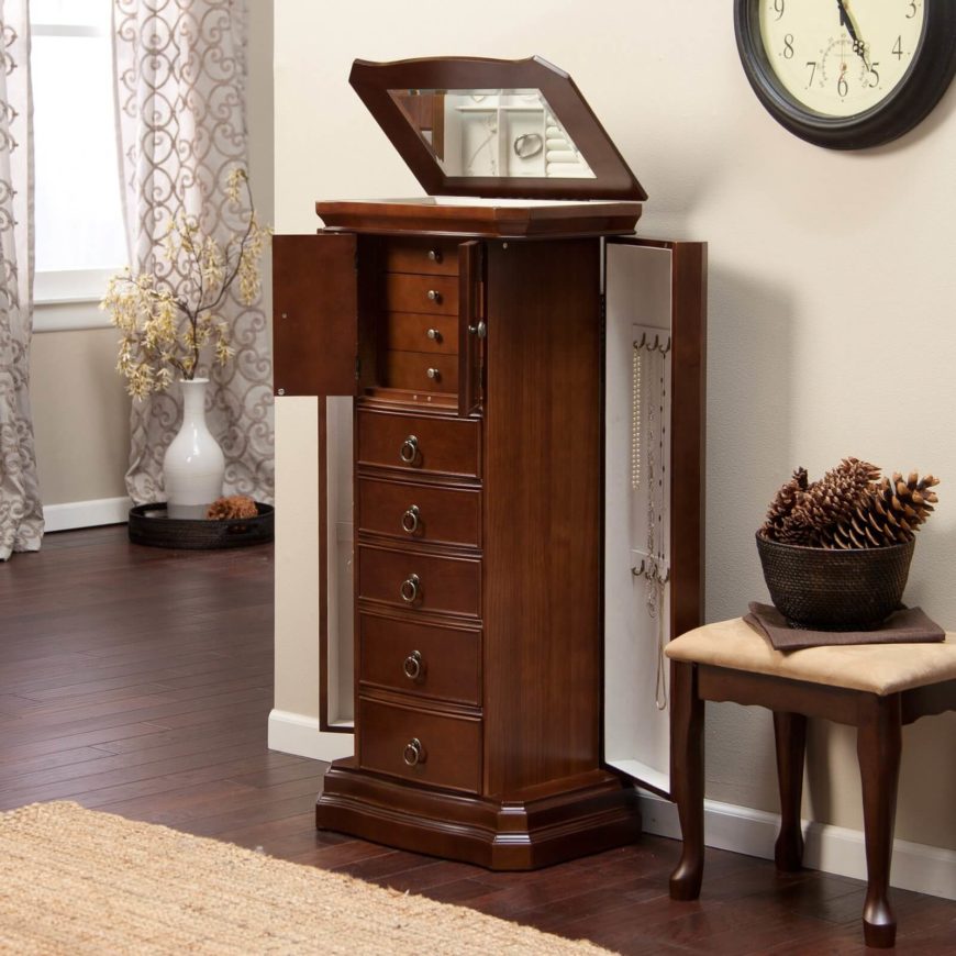 This elegant wooden option features a number of drawers in varying sizes, along with two doors on either side that open to reveal necklace storage. The top conceals ring storage and a mirror. This elegant wooden option features a number of drawers in varying sizes, along with two doors on either side that open to reveal necklace storage. The top conceals ring storage and a mirror.