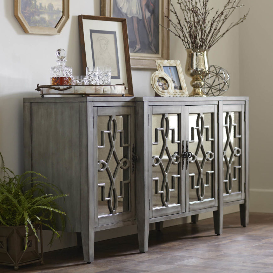 This credenza features a metallic front and an aged facade. This credenza features a metallic front and an aged facade.